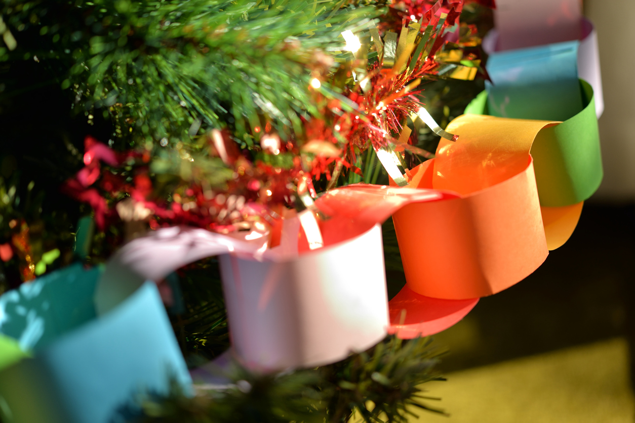 Holiday Pet Travel and Safety, christmas presents under the tree, Homemade rainbow paper chain on Christmas tree, with red and gold tinsel